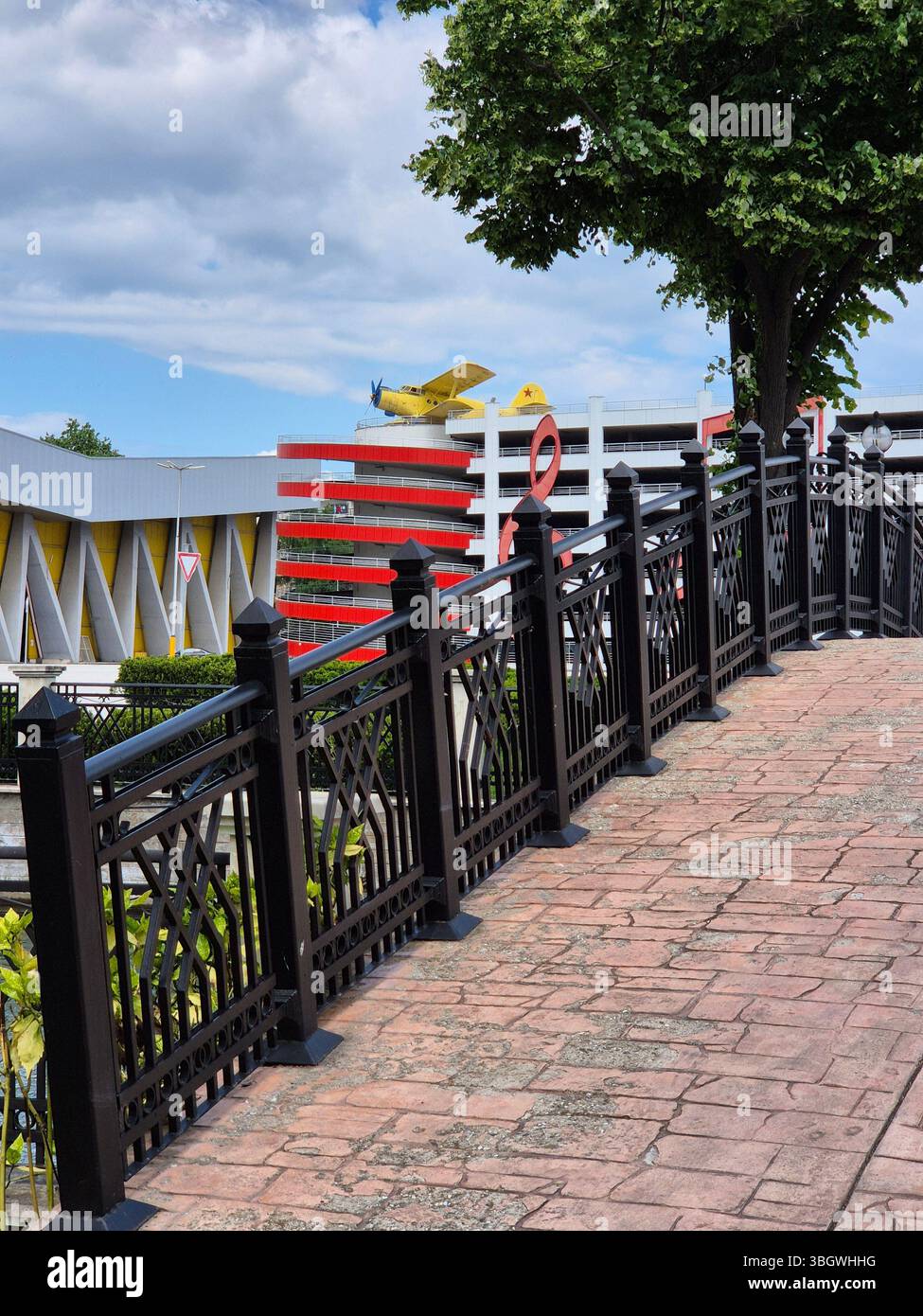 Ein Doppeldecker, mehrstöckiger Parkplatz und ein großes Symbol für den Dreifachschlüssel unter blauem Himmel - Smartphone-aufgenommenes Stockfoto