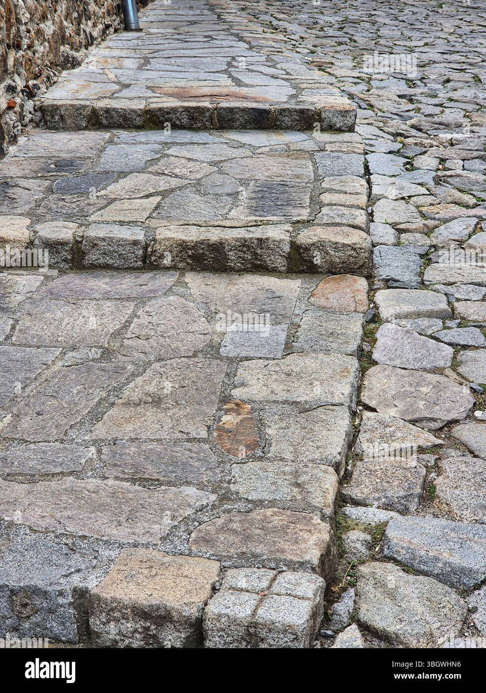 Altes Kopfsteinpflaster. Steinwand Hintergrund. Altes Kopfsteinpflaster, Pflasterstruktur. - Smartphone-aufgenommenes Stockfoto
