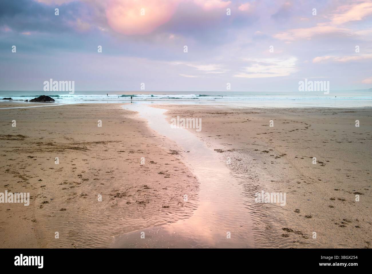 Pastellfarbener Himmel über Ebbe am GT Western Beach an der Küste von Newquay in Cornwall in Großbritannien. Stockfoto