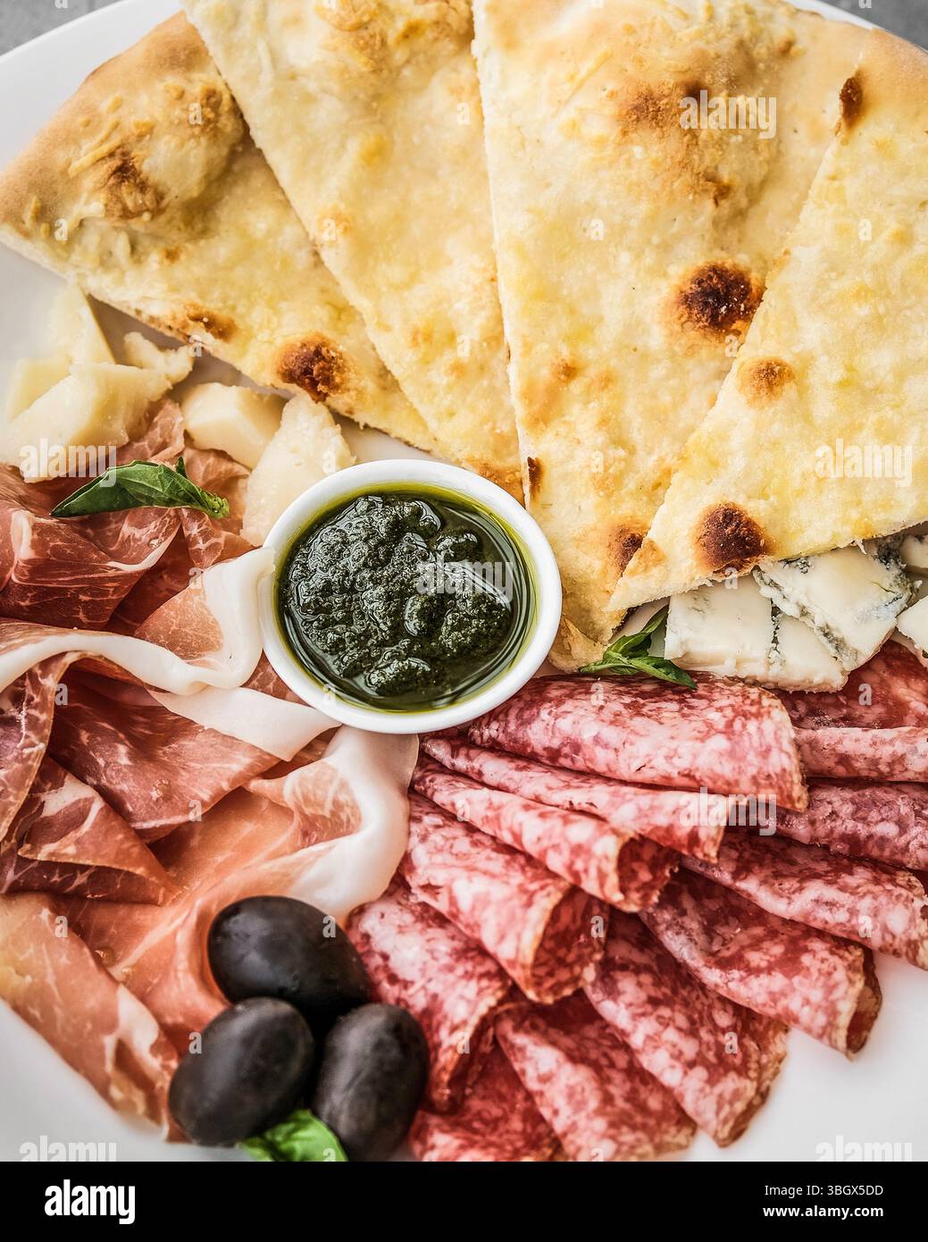 Eine wunderschön arrangierte Artisan Charcuterie Platte mit frischen Zutaten und Saucen Stockfoto