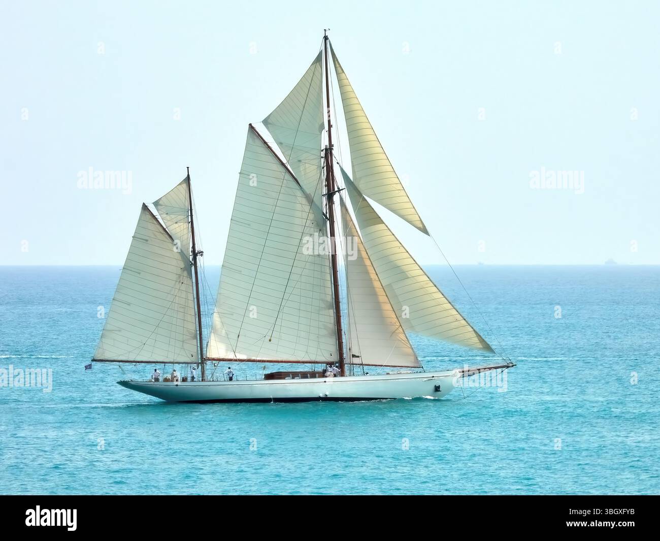 Elegante klassische Segelyacht Black Swan, die an einem sonnigen Tag durch das klare blaue Meer navigiert Stockfoto