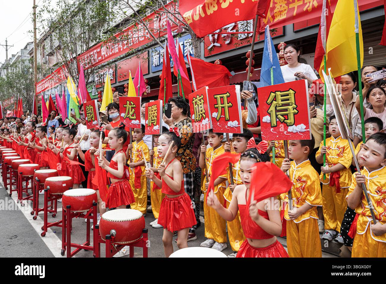 Wuhan, China. Juni 2025. Kinder aus einem örtlichen Kindergarten sahen auf der Straße Trommeln spielen, um sich von den Studenten zu verabschieden, um die jährliche College-Aufnahmeprüfung durchzuführen. Die Studierenden verbringen Monate damit, sich auf die jährliche Prüfung vorzubereiten, und die Ergebnisse bestimmen den Bildungsweg und die zukünftigen Berufsaussichten der Schüler. Insgesamt werden 13,35 Millionen Studenten an drei Tagen an den Prüfungen teilnehmen. (Foto: Ren Yong/SOPA Images/SIPA USA) Credit: SIPA USA/Alamy Live News Stockfoto
