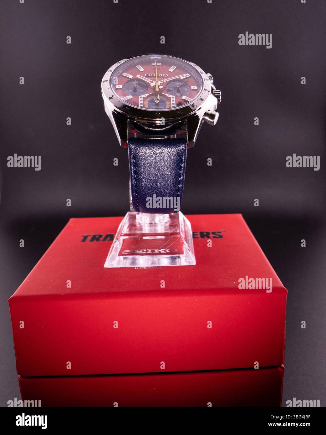 Seiko x Transformers Chronograph Limited Edition für Sammler streng limitierte Seiko Transformers Chronographen-Edition mit markantem, farbenfrohem Zifferblatt im Design des Autobot-Anführers Optimus Prime. Die Uhr entstand als Kooperation zwischen Seiko und der Kult-Marke Transformers und vereint sportliche Chronographenfunktionen mit japanischer Popkultur. Typisch: das rot-blaue Design, das Transformers-Logo auf 12 Uhr sowie spezielle Designelemente aus der Roboter-Serie.die Uhr ist in einer ebenfalls farblich abgestimmten Sammlerbox platziert. Die Komposition richtet sich an Uhrenliebhaber, Stockfoto