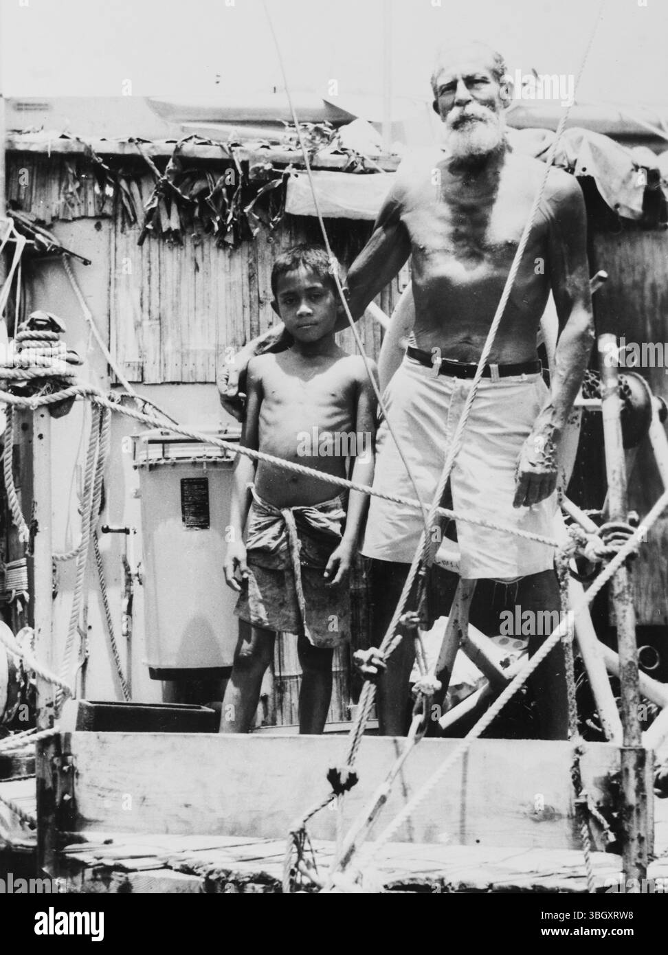 Der Entdecker William Willis, der sein Floß in Faleule anlegte, posiert mit einem kleinen samoanischen Jungen. Er war vier Monate vor seiner Ankunft in Samoa auf See. 21. November 1963 Stockfoto