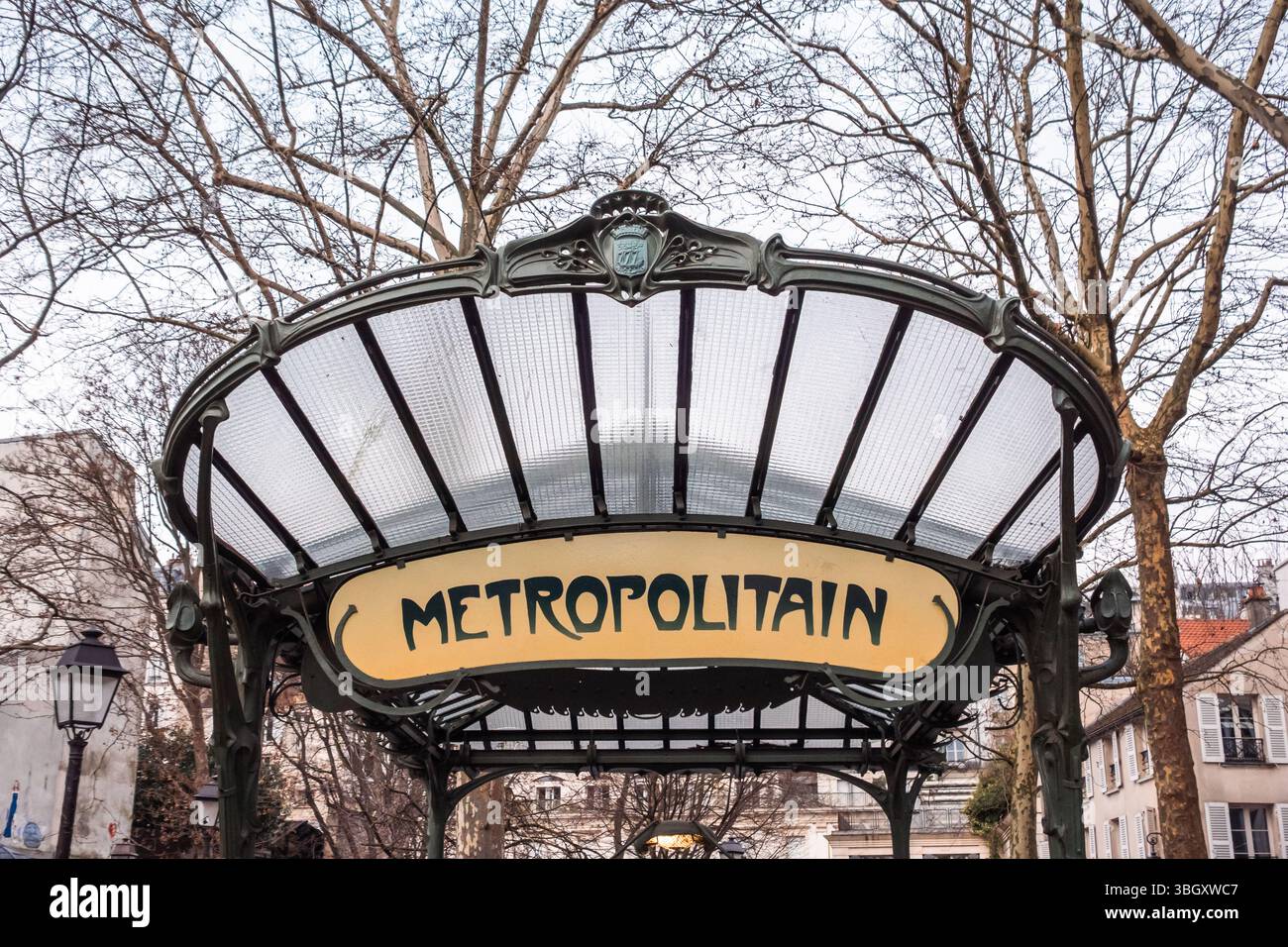 Ein symmetrischer Blick auf einen klassischen U-Bahn-Eingang im Jugendstil „Metropolitain“ in Paris mit seinem unverwechselbaren Glasdach und kunstvollen Eisenwerk fram Stockfoto