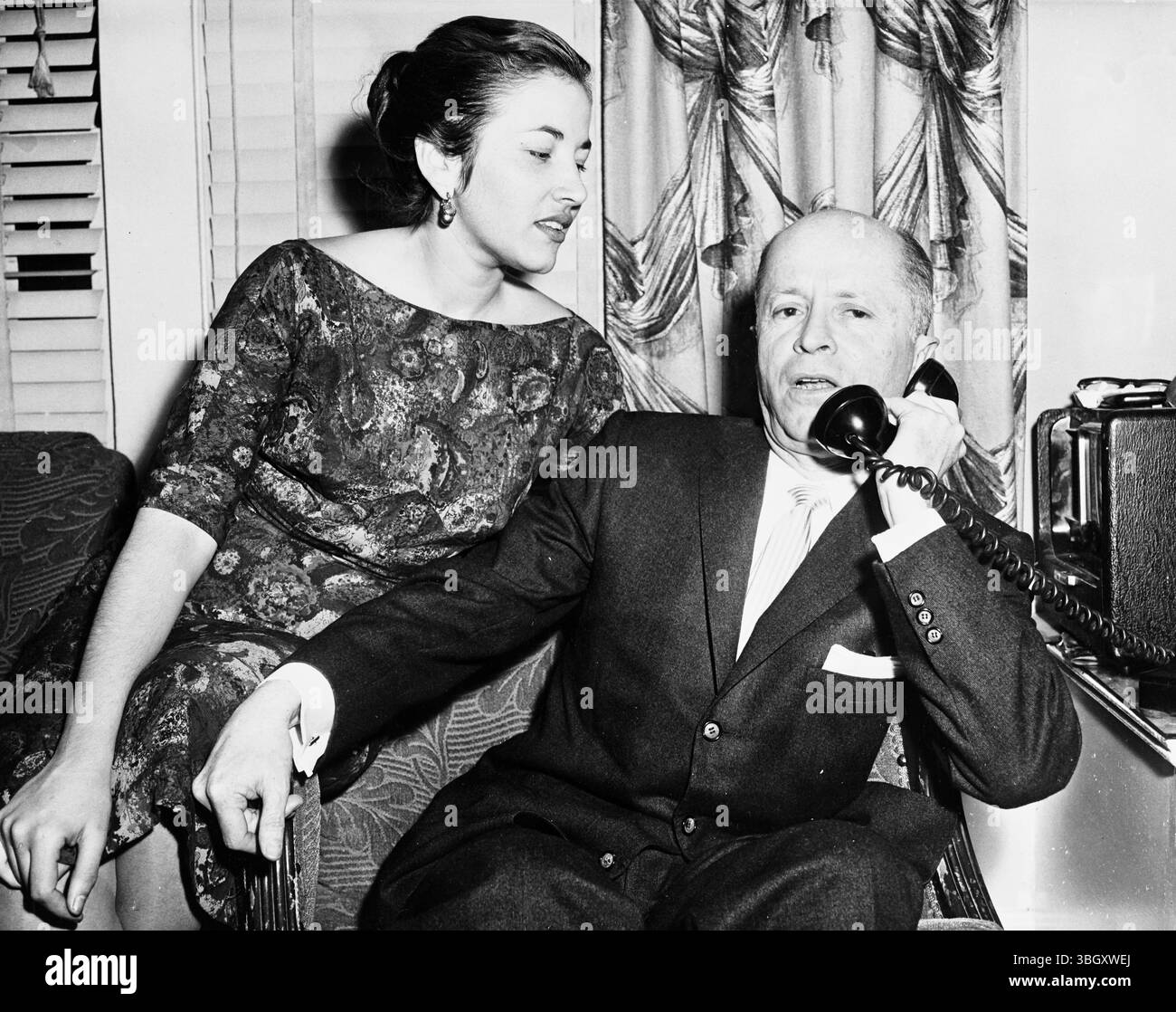 Dr. Jobito Villalva, Vorsitzender der Partei der Demokratischen Union Venezuelas und eines politischen Exils in den USA, erhält telefonische Berichte über die Revolte in Venezuela in seinem Haus in Rego Park, New York, mit Blick auf seine Frau Ismenia. 1. Januar 1958 Stockfoto