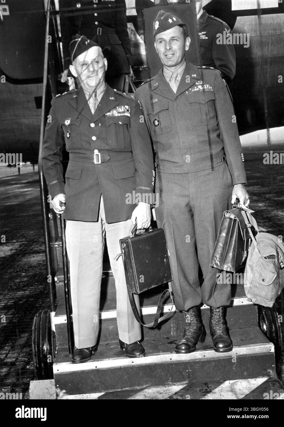 Major General Clarence R. Huebner, 5. corps.commander, (links) und Major General Maxwell D Taylor (rechts), Kommandeur der 101. Luftlandedivision, steigen aus einem Lufttransport auf dem LaGuardia-Feld aus, während sie aus Europa kommen. 3. Juni 1945 Stockfoto