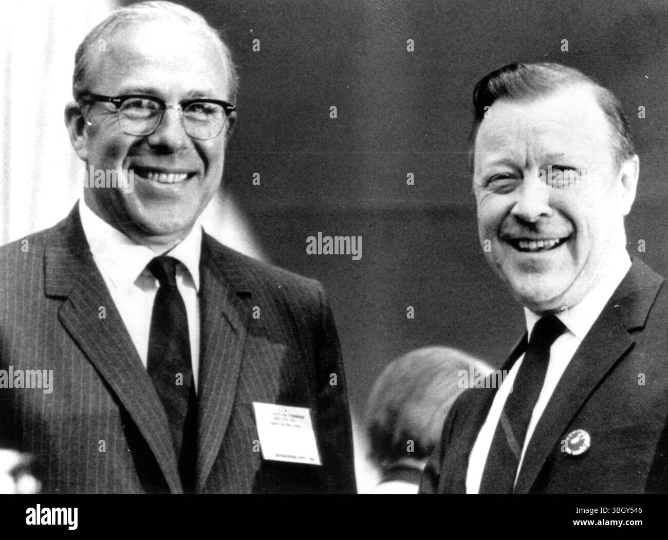 Der US-Arbeitsminister George P Shultz (links) und der Präsident der Vereinigten Autoarbeiter Walter Reuther lächeln alle nach Shultzs Auftritt vor dem 22. Jährlichen Verfassungskonvent der union. 22. April 1970 Stockfoto