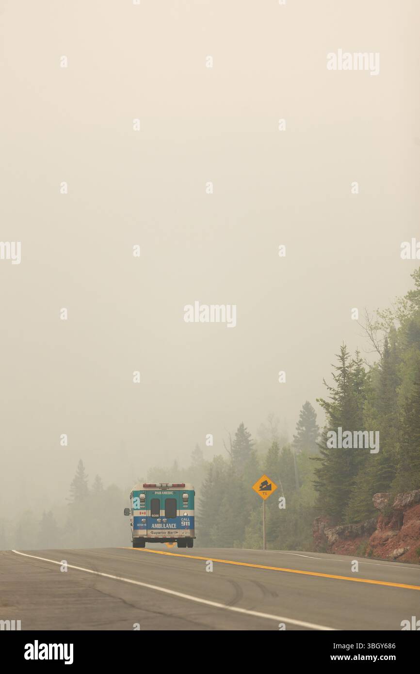 Kama, Kanada - 3. Juni 2025. Rauch von Waldbränden in Manitoba und Nord-Ontario umhüllt die Region, während Fahrzeuge entlang der Trans Canada Highwa fahren Stockfoto
