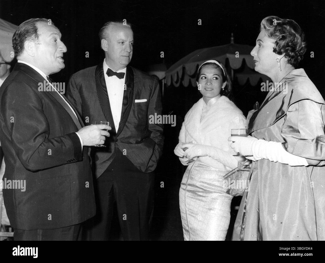 Ich besuche die Einweihung im Sutton Place, der neuen Heimat des reichsten Mannes der Welt, Paul Getty. Vier der 1200 Gäste sind von links nach rechts Sam Spiegel, Michael Frankovich, Filmstar Nancy Kwan und Frau Frankovich. 1. Juli 1960 Stockfoto