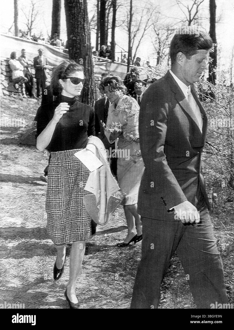 Präsident John Fitzgerald Kennedy und Jacqueline Kennedy, gefolgt von der Schwester des Präsidenten, Frau Jean Smith, spazieren um den Glenwood Park in Middleburg. Der Präsident blieb nicht, um die 40. Jahrestagung des Middleburg Hunt Race zu sehen, aber er sah sich den Kurs an. 15. April 1961 Stockfoto