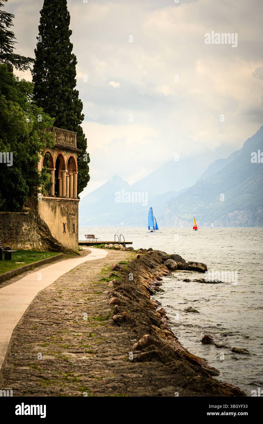 Segelboote auf dem Gardasee mit italienischer Architektur im Vordergrund. Stockfoto