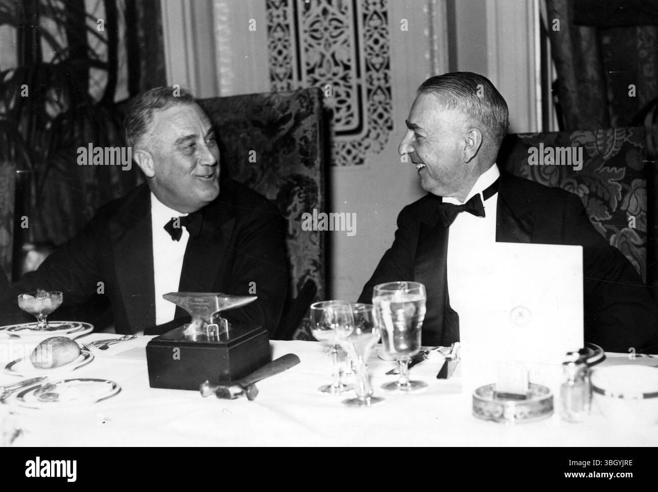 Roosevelt nimmt an einem Bankett des National Press Club Teil. P. Franklin D Roosevelt, gezeigt (links), als er am Bankett des National Press Club in Washington, DC, teilnahm. Angemessen düsterer Geschäftsführer ist Mark Foote, Präsident des Clubs. 2. März 1935 Stockfoto
