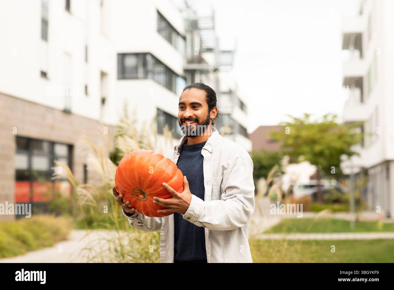 Junger Mann mit Kürbis in der Stadt Stockfoto
