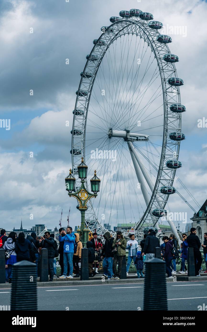 An einem bewölkten Tag versammelten sich Menschenmassen in der Nähe des London Eye Stockfoto