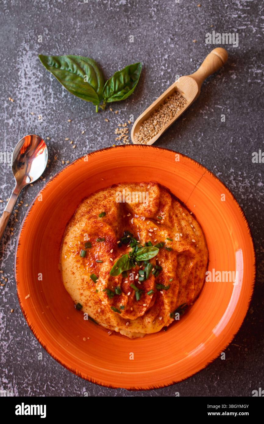 Köstlicher hausgemachter Hummus garniert mit Paprika Stockfoto