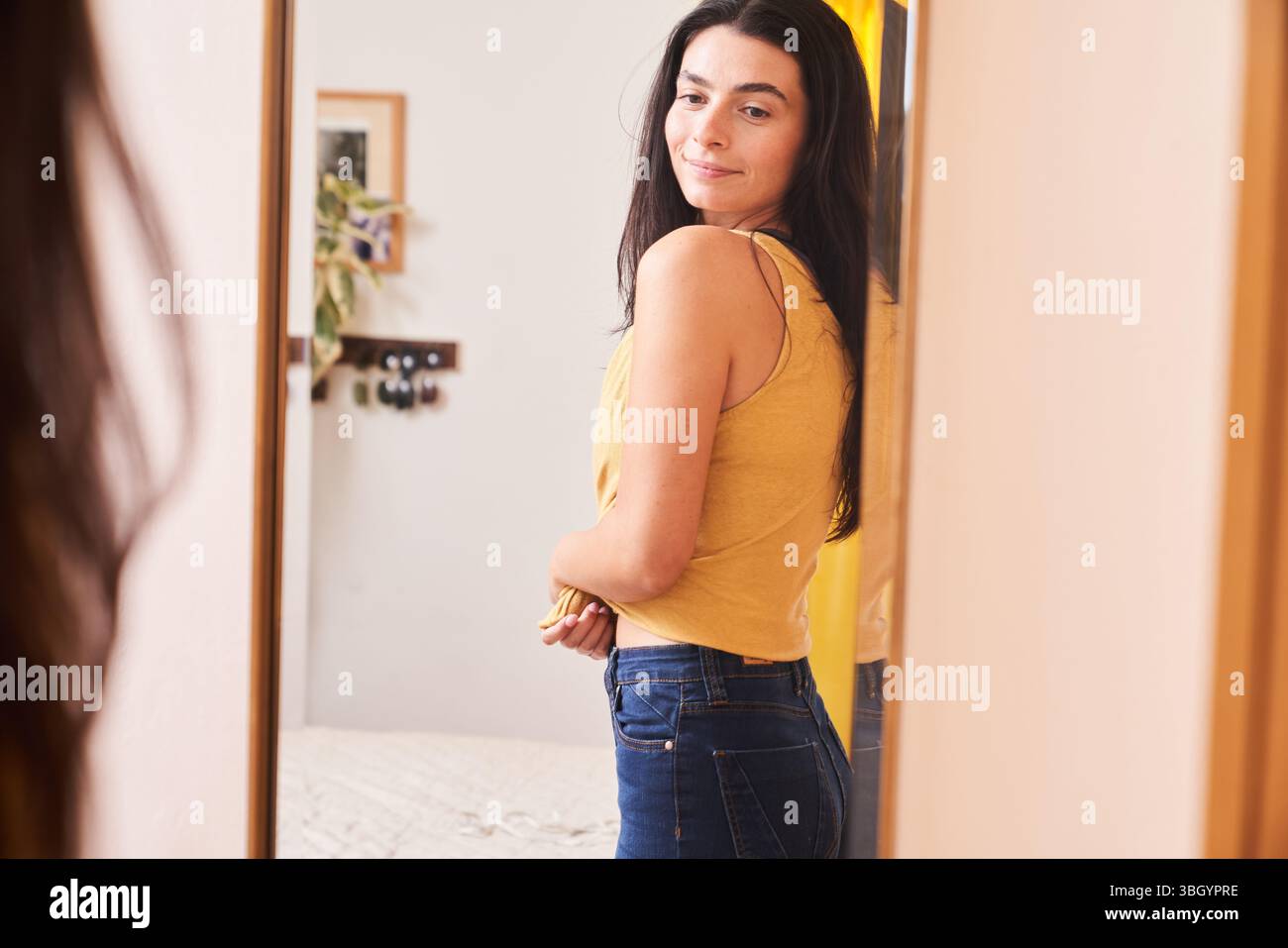 Frau, die selbstbewusst in den Spiegel schaut Stockfoto