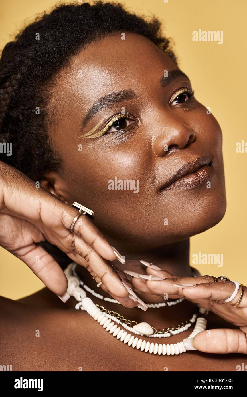 Eine junge afroamerikanische Frau zeigt ihre strahlende Haut, während sie anmutig posiert. Stockfoto