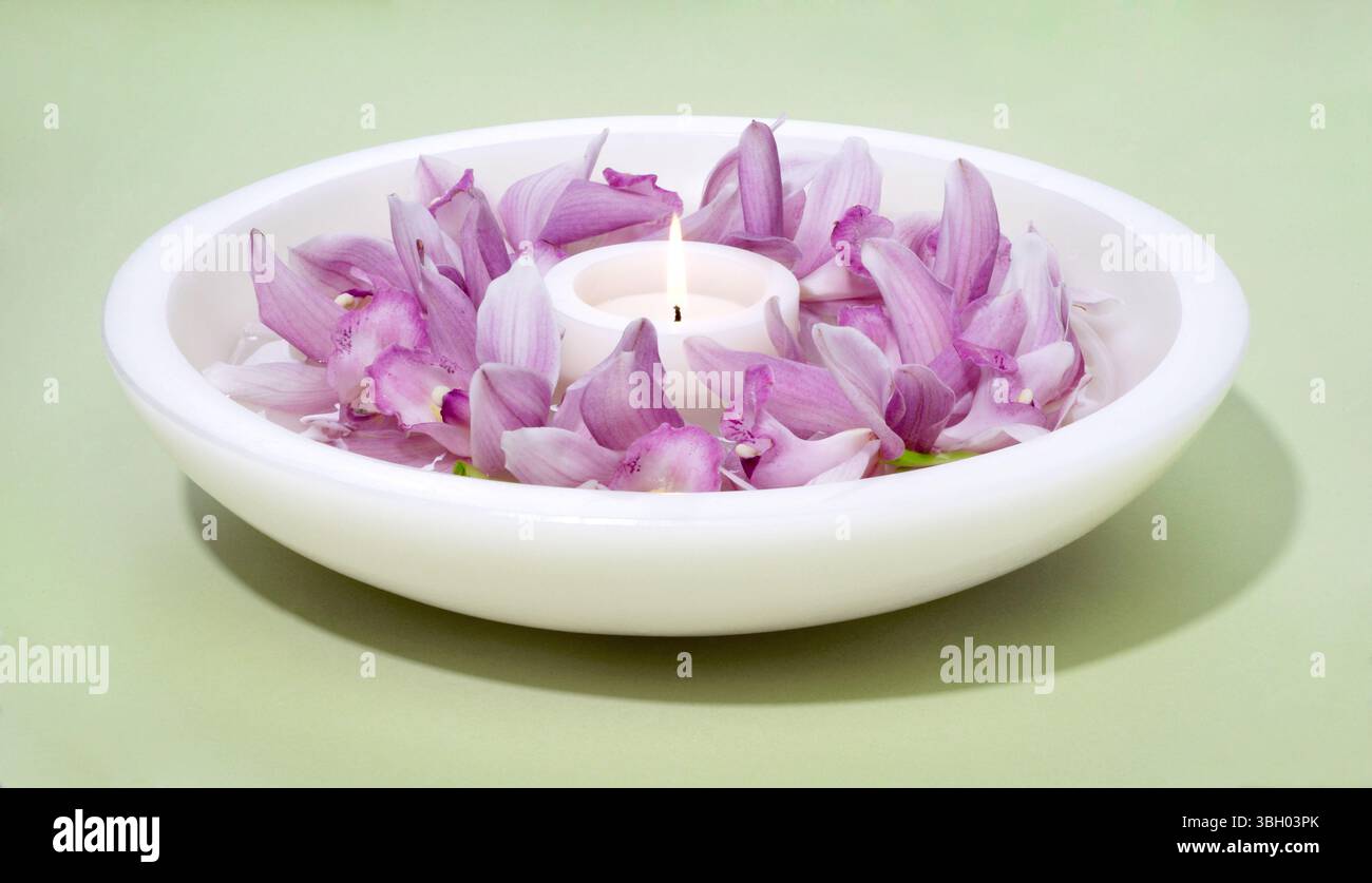 Beleuchtete Kerze auf weißem Hintergrund Stockfoto