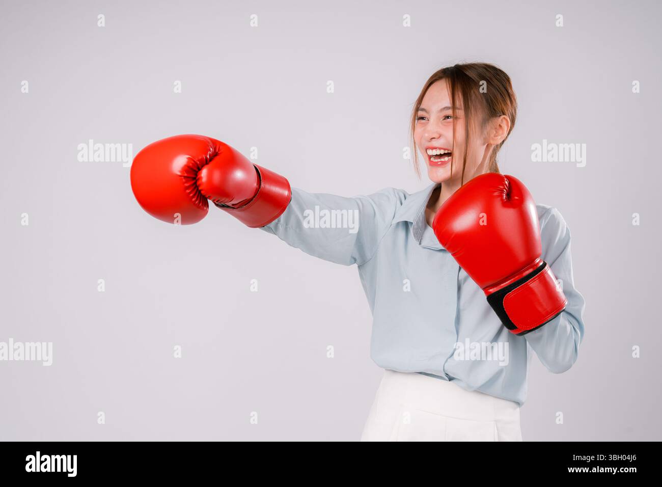 Frau Übung Punch Kickboxen Hintergrund Stärke starker Trainingshandschuh Person, Eine starke weibliche Athletin in Aktion demonstriert Fitness und Determi Stockfoto