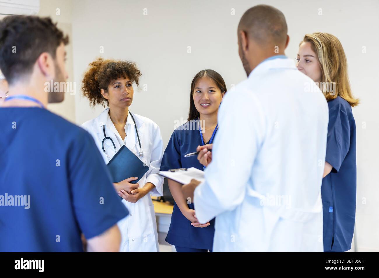 Verschiedene medizinische Fachkräfte arbeiten zusammen, tauschen Fachwissen aus und prüfen Patientendaten während einer produktiven Besprechung im Krankenhaus Stockfoto