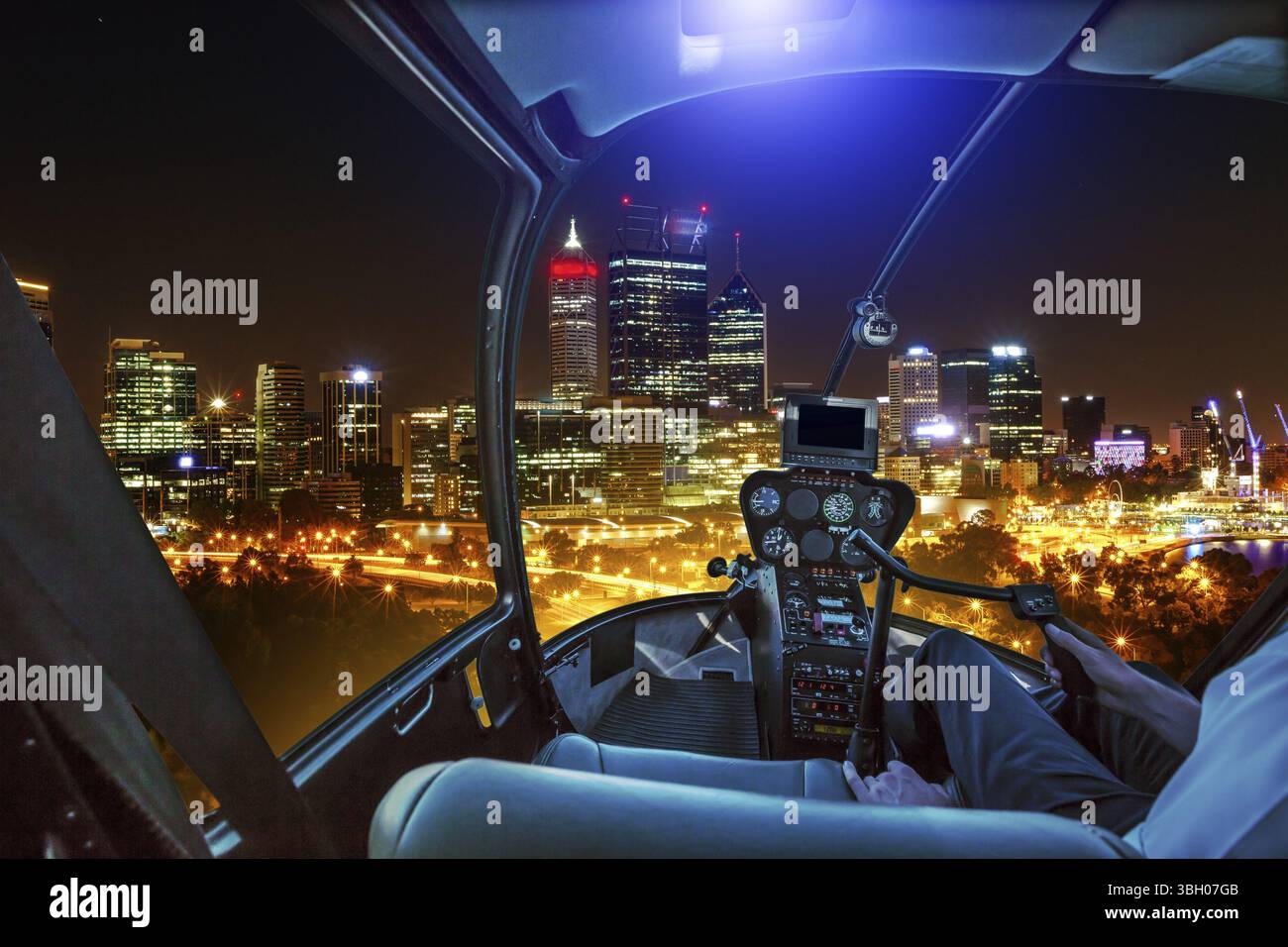 Helicopter Cockpit Innenraum fliegen auf Central Business District auf der Swan River widerspiegelt. Rundflug über die Skyline von Perth, Western Australia. Nacht Stockfoto