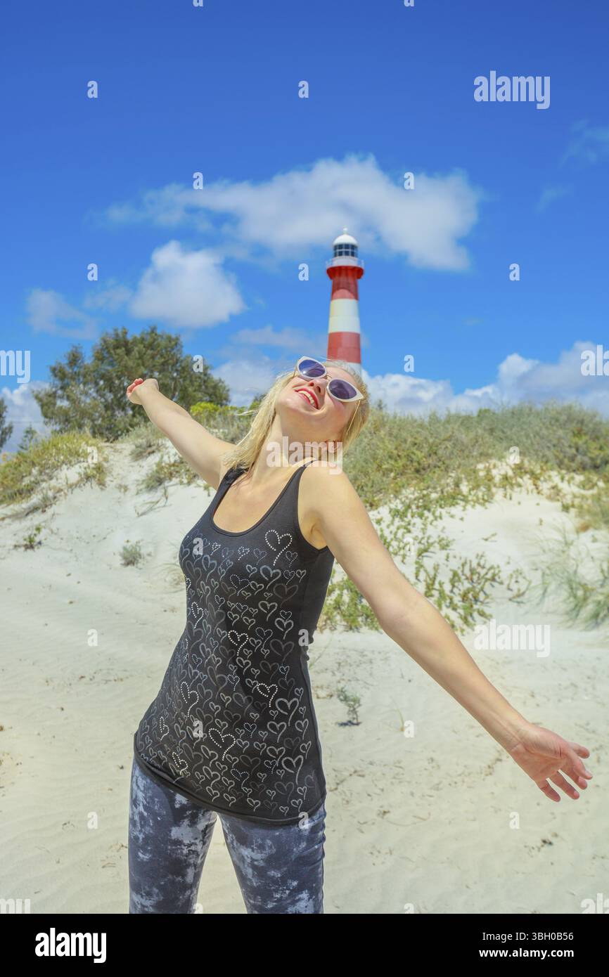 Freiheit Frau am weißen Strand mit Dünen in Geraldton, Western Australia. Weibliche genießt bei historischen und legendären Moore Lighthouse Point 1878 in gebaut Stockfoto