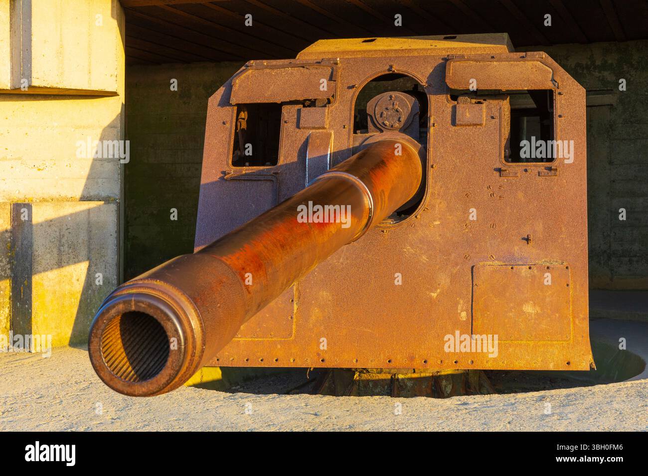 Ein Küstengewehr der Longues-sur-Mer-Batterie bei Sonnenuntergang, Teil der Küstenbefestigung der deutschen Atlantikmauer in Longues-sur-Mer (Calvados), Frankreich Stockfoto