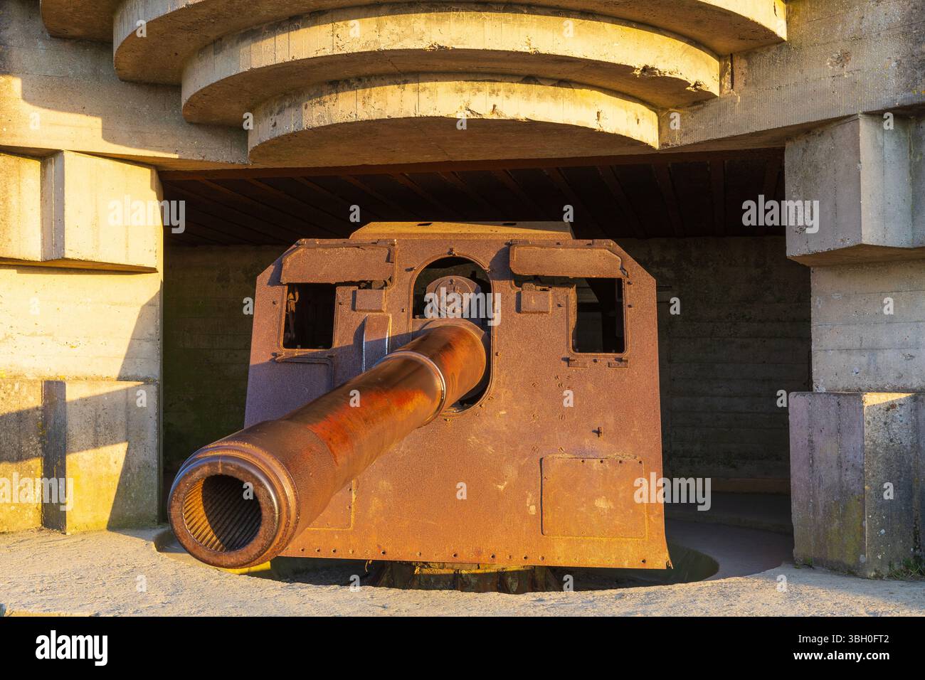 Ein Küstengewehr der Longues-sur-Mer-Batterie bei Sonnenuntergang, Teil der Küstenbefestigung der deutschen Atlantikmauer in Longues-sur-Mer (Calvados), Frankreich Stockfoto