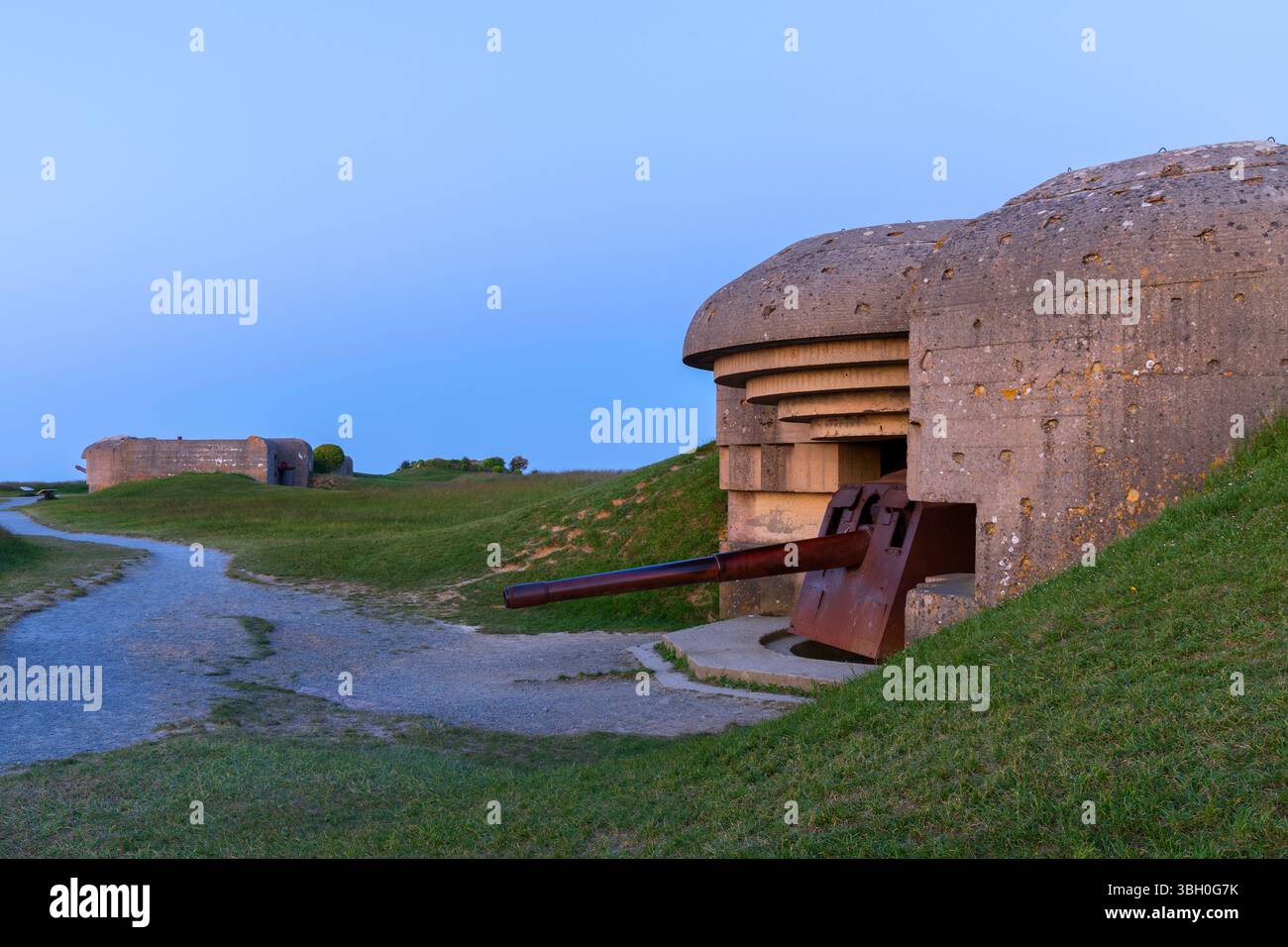 Ein Küstengewehr der Longues-sur-Mer-Batterie in der Abenddämmerung, Teil der deutschen Küstenbefestigung an der Atlantikmauer in Longues-sur-Mer (Calvados), Frankreich Stockfoto