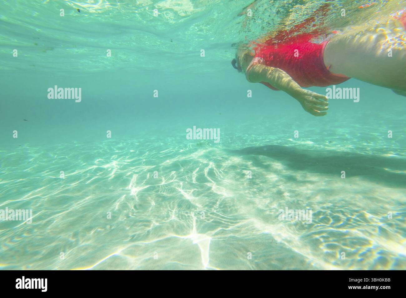 Weibliche Apnoe unter Wasser mit rosafarbenem Neoprenanzug. Schnorchelin schwimmt in Dänemark, Westaustralien. Greens Pool, William Bay NP. Wassersport in Au Stockfoto