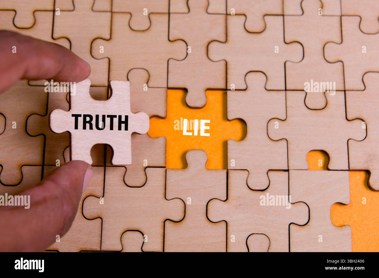 Händige ein Puzzleteil mit der Markierung Wahrheit in ein hölzernes Puzzle mit einem Stück mit der Bezeichnung Lüge ein, das Entscheidungen symbolisiert. Stockfoto