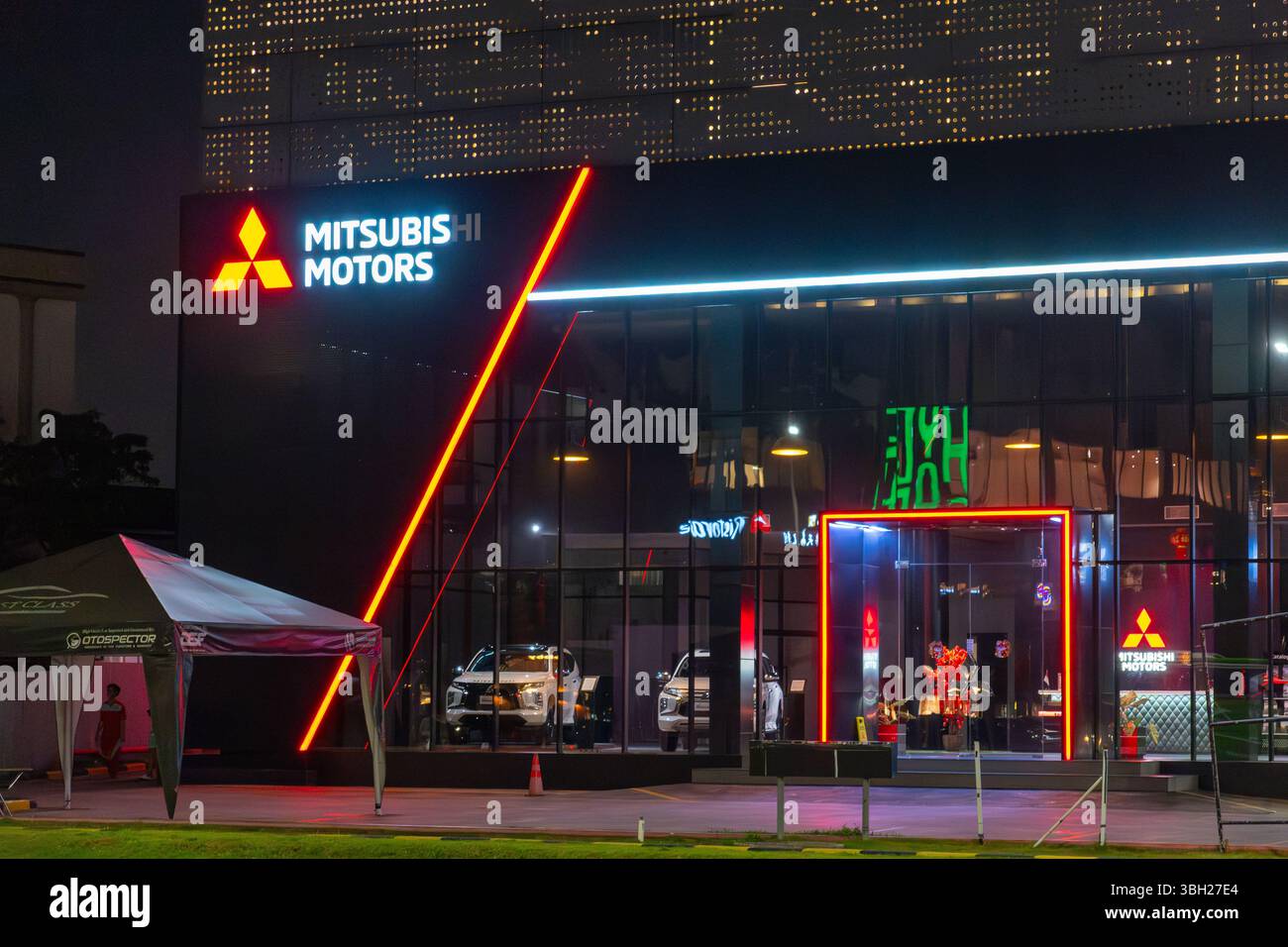 Jakarta, Indonesien - 9. Februar 2025: Gebäude von Mitsubishi Motors mit Neonlichtern. Das Gebäude ist nachts beleuchtet Stockfoto