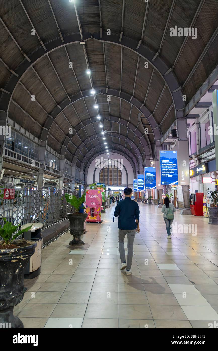 Jakarta, Indonesien - 9. Februar 2025: Bahnhof Jakarta Kota bei Nacht. Der Mann läuft einen langen Flur entlang. Der Flur ist beleuchtet Stockfoto