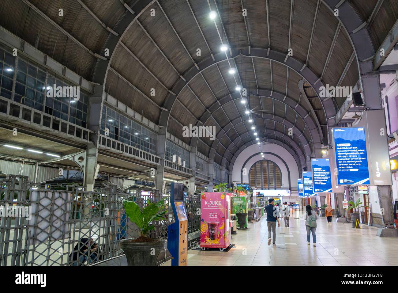 Jakarta, Indonesien - 9. Februar 2025: Bahnhof Jakarta Kota bei Nacht. Der Mann läuft einen langen Flur entlang. Der Flur ist beleuchtet Stockfoto