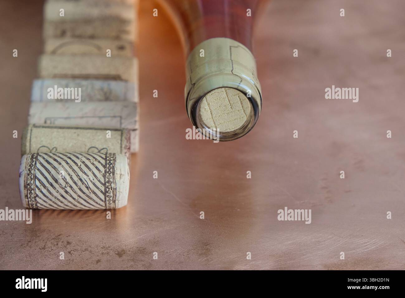 Synthetische Weinkorken auf dem Hintergrund einer Korkflasche Rosenwein. Stockfoto