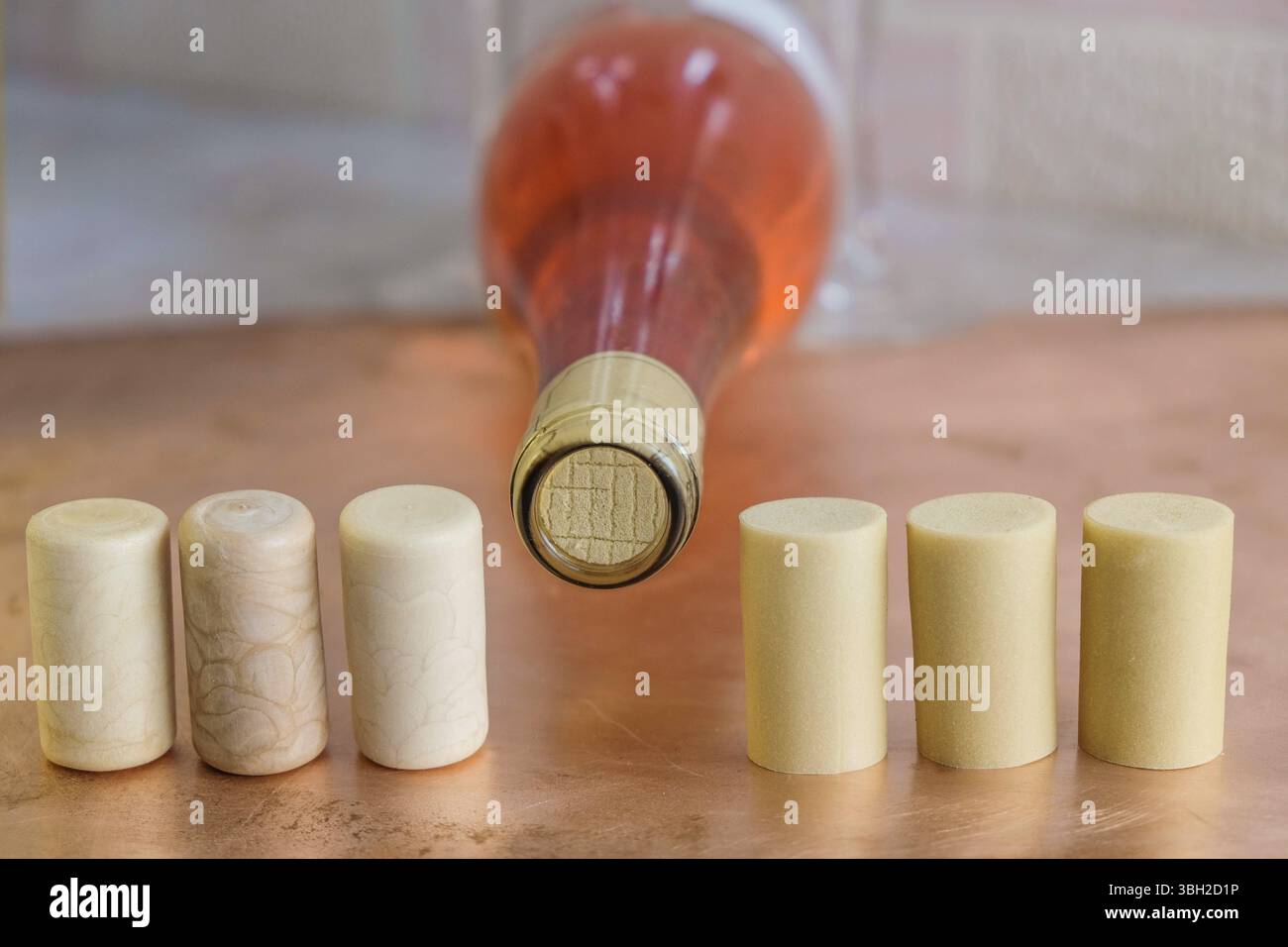 Synthetische Weinkorken auf dem Hintergrund einer Korkflasche Rosenwein. Stockfoto
