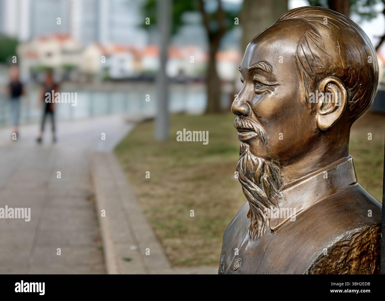 Eine Büste von Ho Chi Minh durch eine Promenade an der North Boat Quay, Singapore River, Singapur, Teil von mehreren Büsten berühmter Persönlichkeiten entlang des Flusses Stockfoto