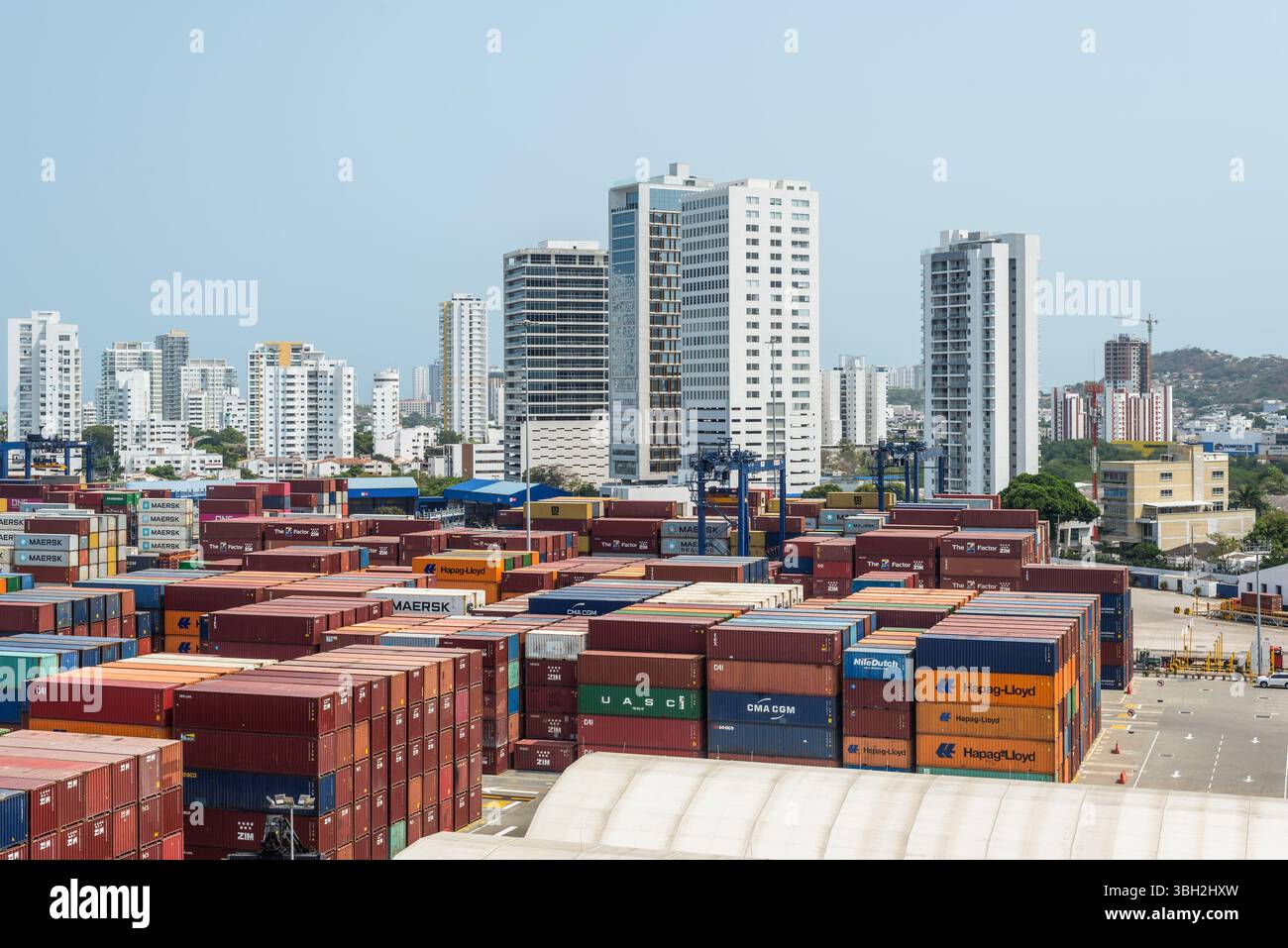 Cartagena, Kolumbien - 12. April 2024: Der Hafen ist eine lebendige Szene, mit Containern vor dem Hintergrund hoher Wohngebäude in C Stockfoto