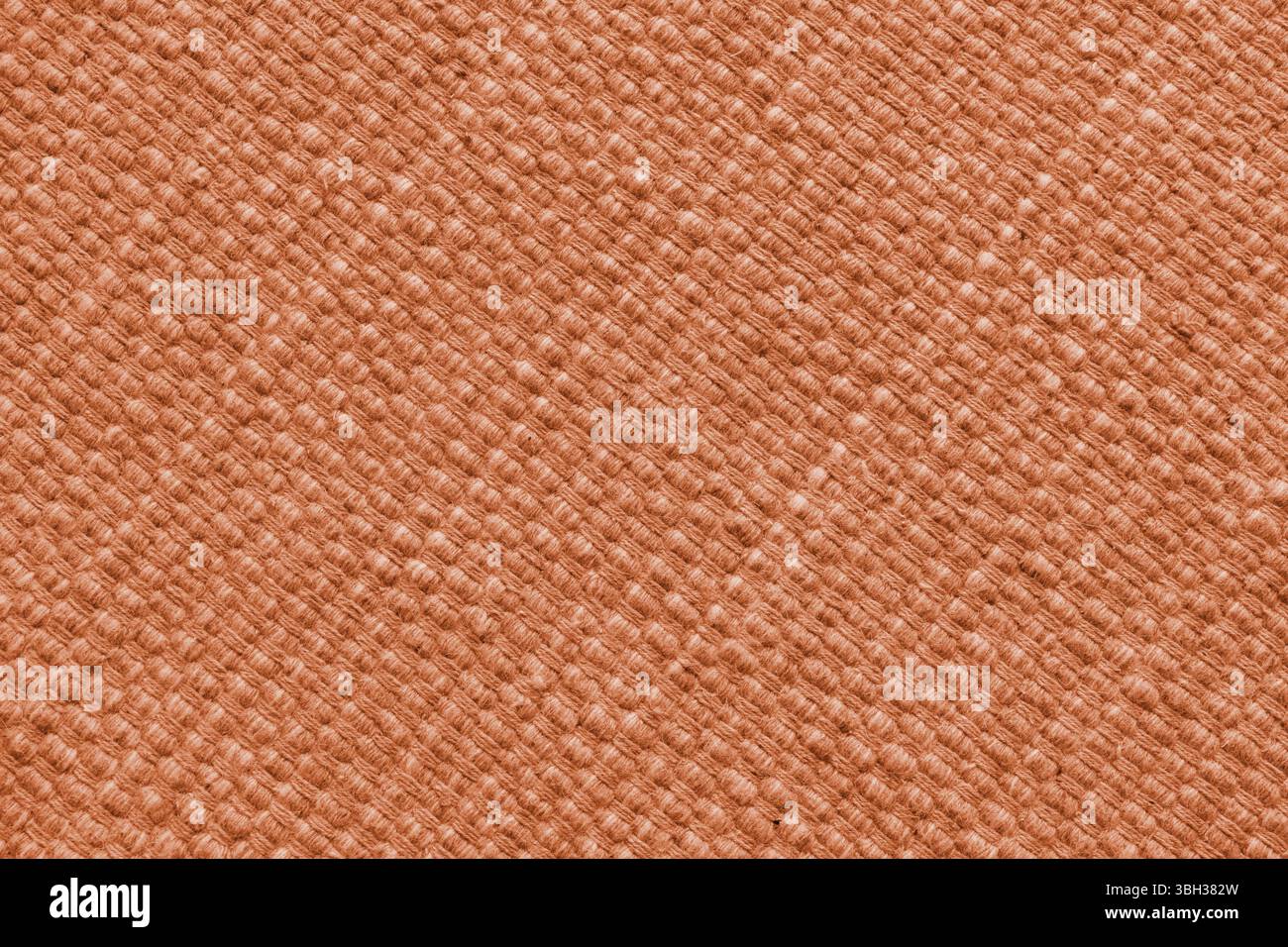 Textur aus orangefarbenem Naturgewebe mit großer Diagonalbindung. Oberfläche, Struktur von Polstern oder Teppichmaterial, Stoffhintergrund aus der Nähe. Stockfoto