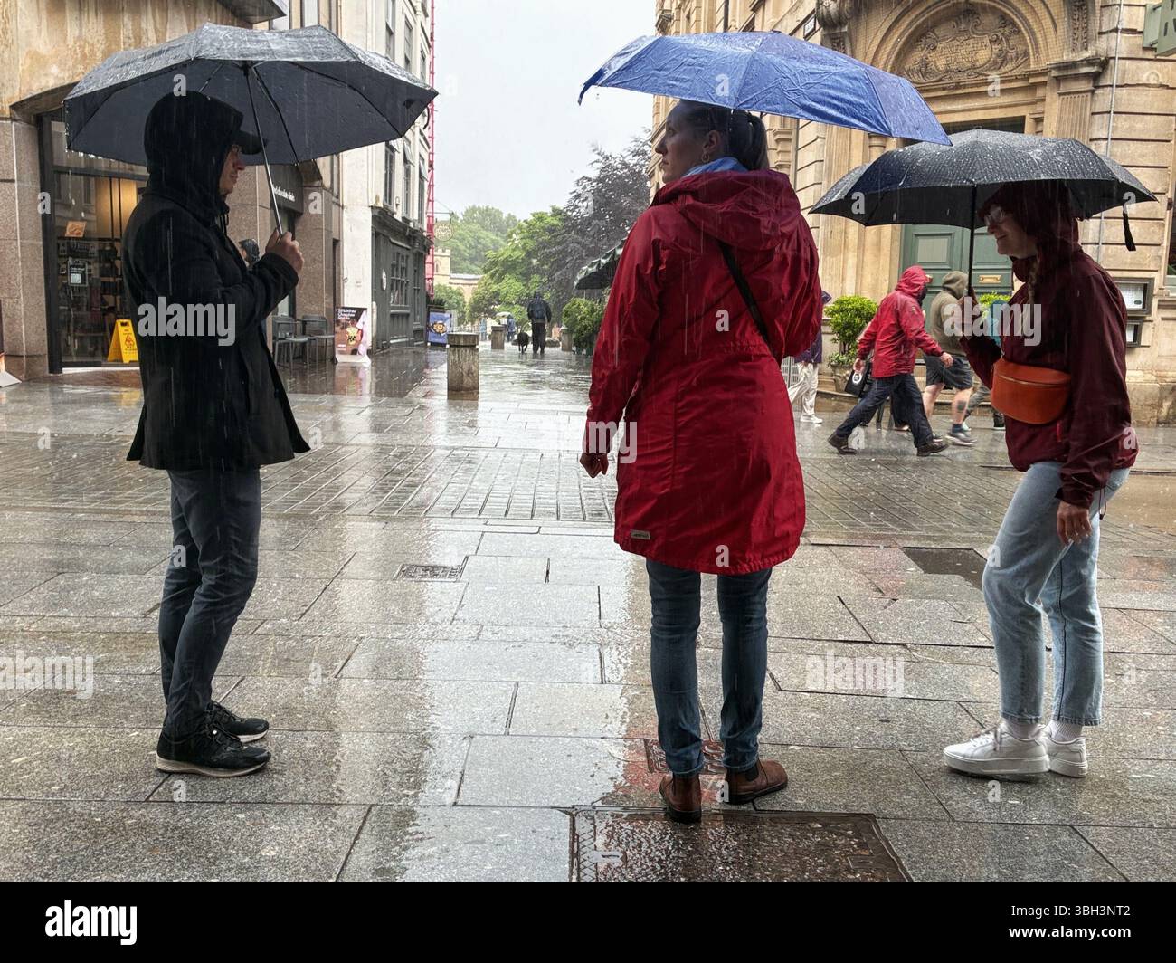 Exeter, Devon, Großbritannien. Juni 2025. Wetter in Großbritannien: Starker Regen in Exeter, Devon. Im Bild: Menschen mit Sonnenschirmen an einem regnerischen Tag im Zentrum von Exeter. Hinweis: Nidpor/Alamy Live News Stockfoto