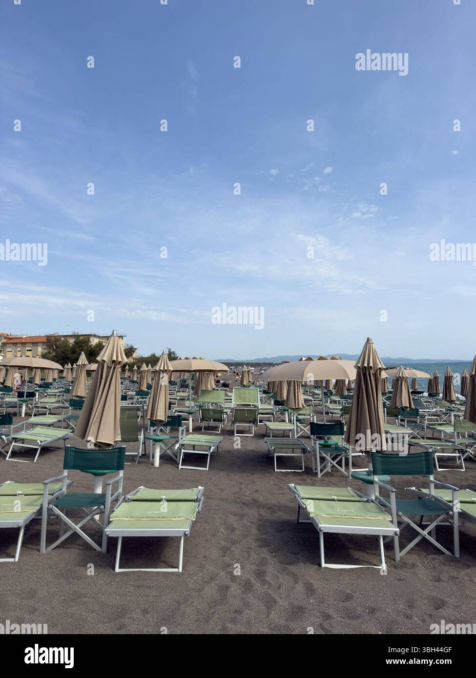 Sonnenschirme und Liegestühle am Morgenstrand - Smartphone-aufgenommenes Stockfoto