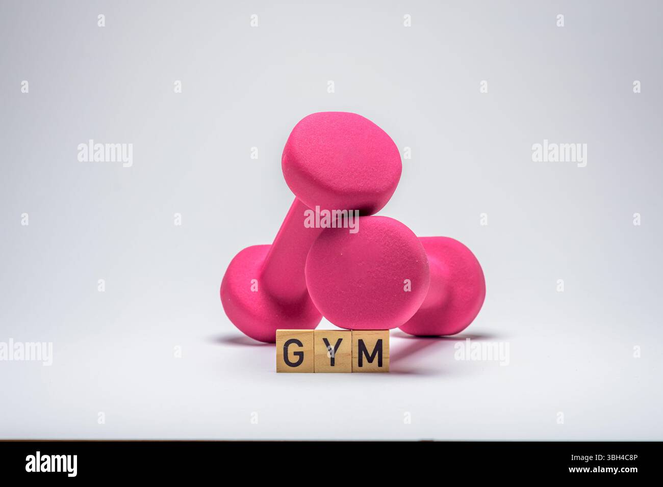 Zwei Kurzhanteln mit Holzklötzen, die den Fitnessraum beschreiben. Fitnesskonzept Stockfoto