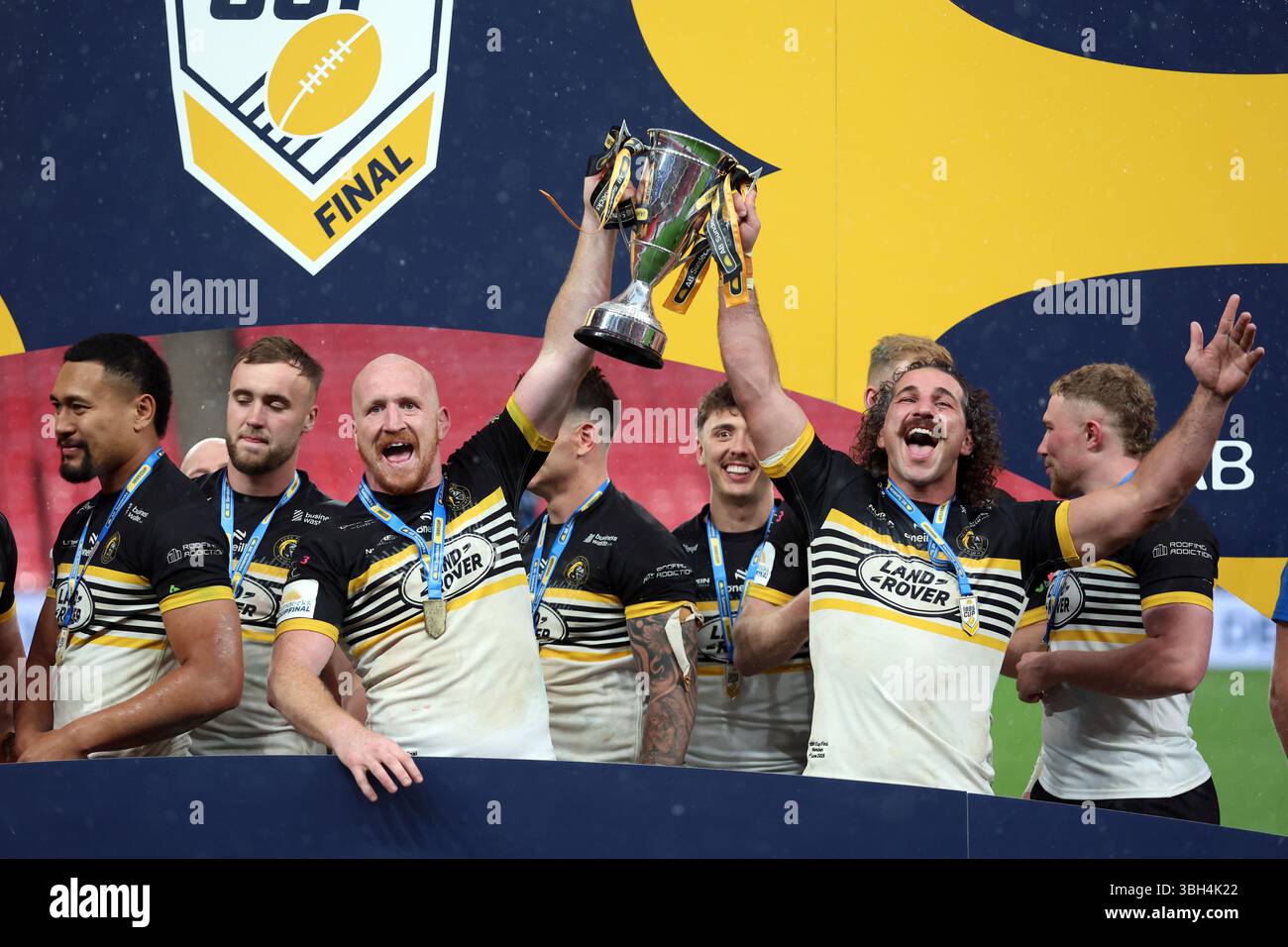 Brendan Santi der York Knights (rechts) und Jordan Thompson der York Knights feiern mit der Trophäe nach dem Cup-Finale 1895 im Wembley Stadium, London. Bilddatum: Samstag, 7. Juni 2025. Stockfoto