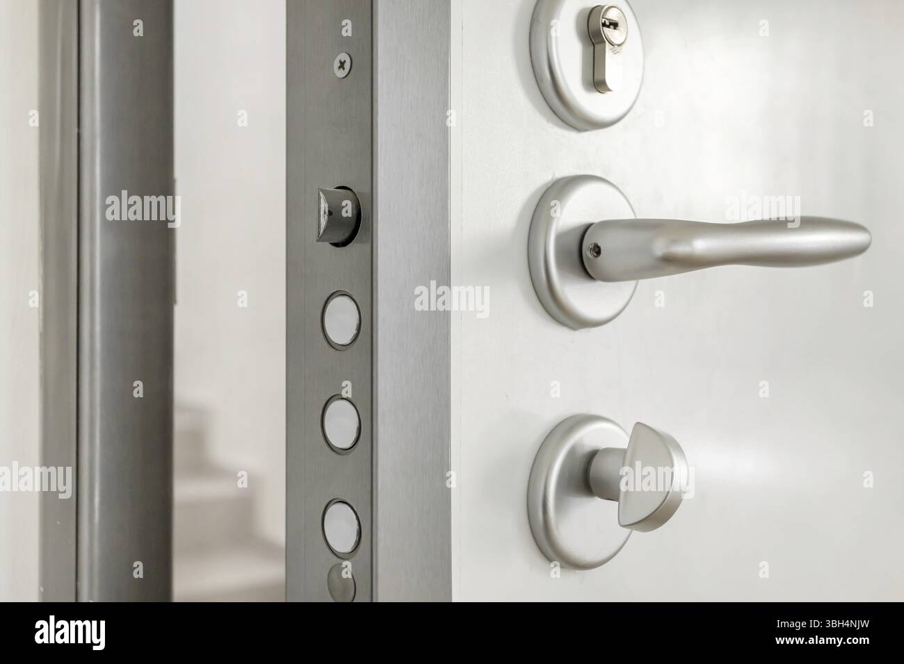 Nahaufnahme: Hochsicherheitsschloss einer weißen gepanzerten Haustür Stockfoto