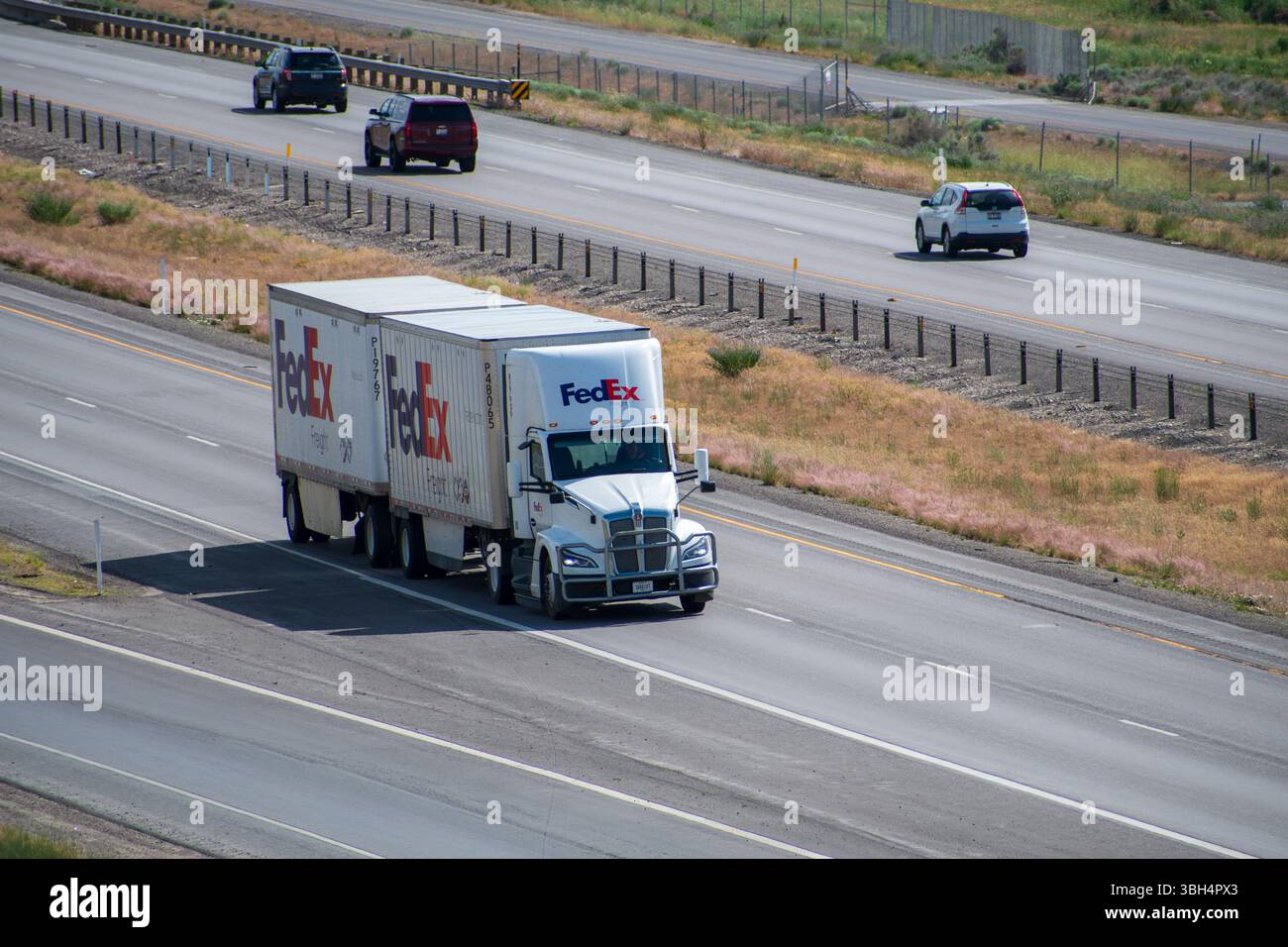 SANTAQUIN, UT – 8. JUNI 2025: FedEx Truck auf I-15 transportiert zwei Container. FedEx ist ein globales Kurier- und Logistikunternehmen mit Sitz in Memphis, Tennessee. Stockfoto
