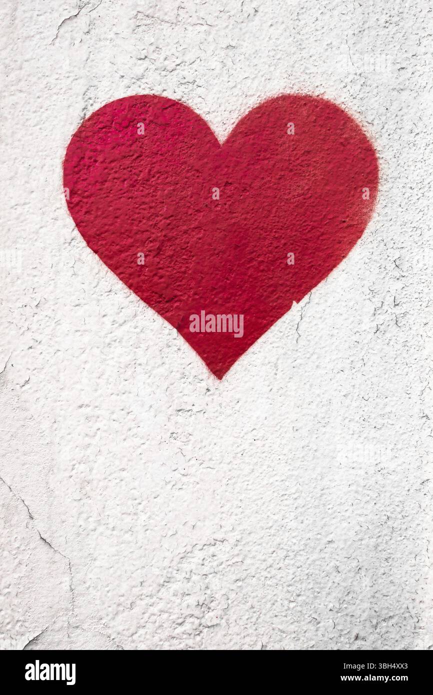Rotes Liebesherz Hand auf grungy Wand gezeichnet. Trendiger Street-Style mit strukturiertem Hintergrund. Kopierbereich Stockfoto