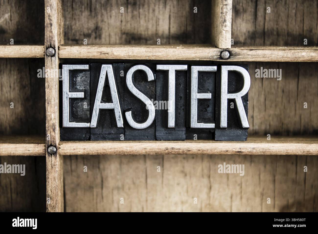 Das Wort OSTERN in Vintage-Metall-Buchdruck geschrieben in einer Holzschublade mit Trennwänden Stockfoto