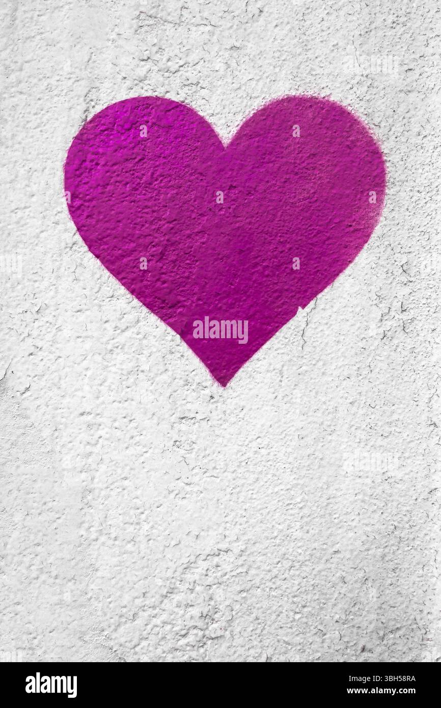 Rosa Liebesherz Hand auf grungy Wand gezeichnet. Trendiger Street-Style mit strukturiertem Hintergrund. Kopierbereich Stockfoto