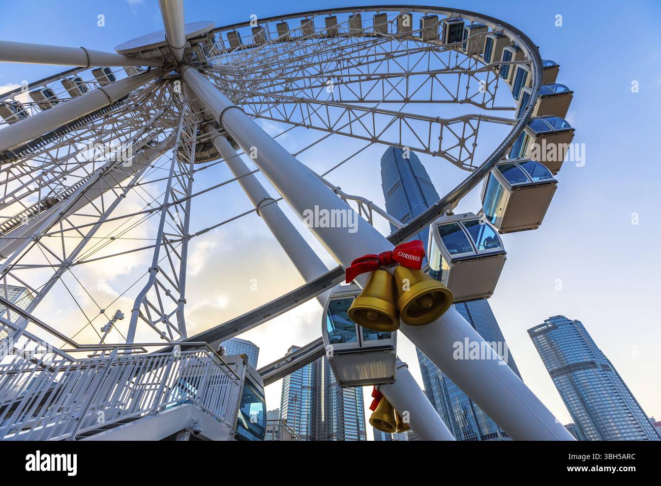 Das beliebte Wahrzeichen-Aussichtsrad auf der Insel Hong Kong in der Dämmerung in der Nähe der Ferry Pier Arera mit Wahrzeichen im Hintergrund. Perspektivische Ansicht von Stockfoto